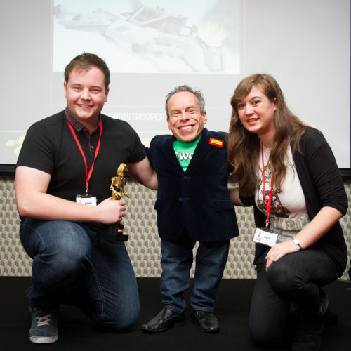 Daniel Jameson, with partner, receiving his Golden Brickie award from Warwick Davis